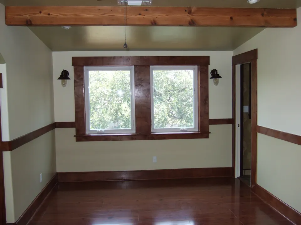 Upstairs addition room with exposed beams and stained trim