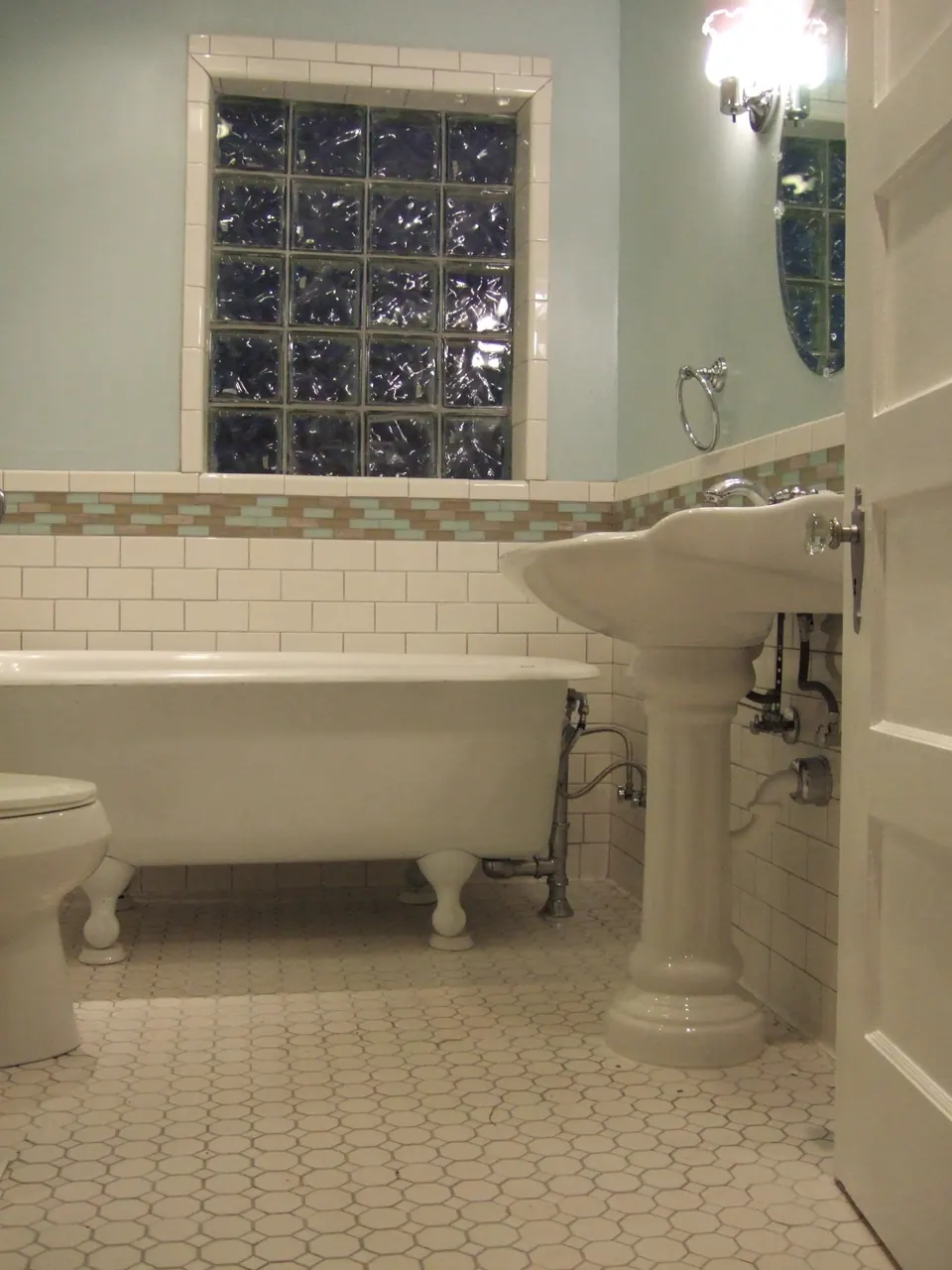 Bathroom after the remodel with clawfoot tub and pedestal sink
