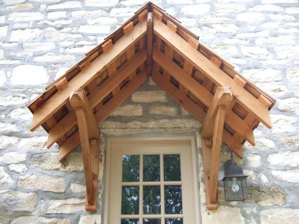 Cedar timber-frame awning built over a window in a limestone wall