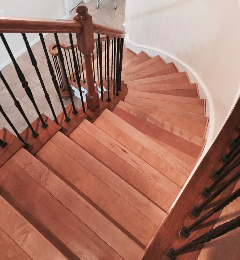Curved staircase with wood treads and iron balusters