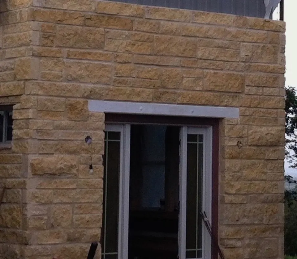 Cut limestone masonry framing a glass patio door
