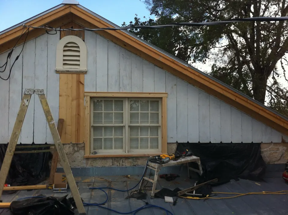 Ranch house gable during the repair: new wall, restored siding and gingerbread going up