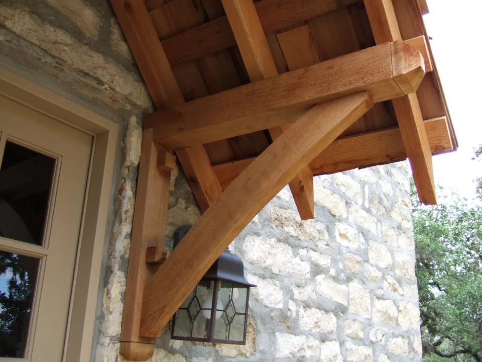 Heavy timber brackets carrying a porch roof on a limestone home